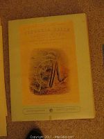 Photo of the cover print of the portfolio, titled 'Victoria Falls Zambesi River Sketched on the Spot by T. Baines, F.R.G.S.', showing a detailed etching of the falls and river.