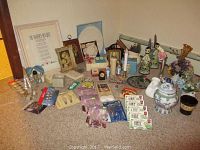 Wide view of all items placed on carpet showing framed pictures, artificial flowers, candles, and figurines.