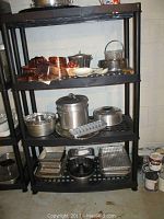 Shelf with various copper-colored Foley sift chine cookware pieces, baking pans, and molds arranged on black shelving unit
