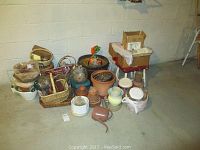 Overview of the lot showing multiple garden pots stacked and arranged with woven baskets, boxes, and other gardening items on the floor.