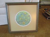 Framed original etching with floral depiction in circular format, beige mat, gold ornate frame.