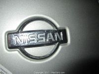 Close-up image of Nissan chrome wheel cover with emblem