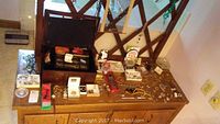 Overview of wooden jewelry box closed and assortment of jewelry on table