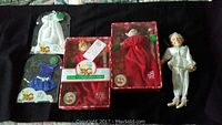 Two Elf Magic dolls in original boxes, two new outfits in blister packs, and fairy grandma doll on black background.