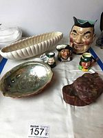 Overview of all lot items including Toby jugs, ceramic centerpiece, abalone shell, and rock specimen