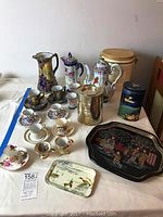 Full view of all tea sets, cups, plates, tins, trays and cookie jar.