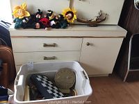 Overview of the collection showing dolls, chessboard, medallion container, Looney Tunes bank, and decorative boat figurine on dresser.