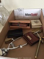 Lot contents placed inside a cardboard box showing all personal grooming and accessory items.