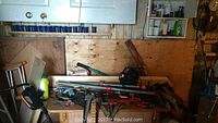 Overview of hand tools and power tools including clamps, wrenches, jigsaw and drill on a wooden workbench