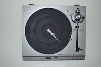 Front view of the Onkyo turntable re-purposed as a functioning clock with white clock hands on the black rubber platter.