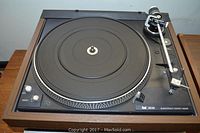 Overhead view of Dual 606 turntable showing platter, tonearm, and control panel in wood grain plinth