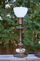 Full view of vintage Art Deco bronze or brass table lamp with milk glass tulip shade, showing height and overall design.