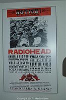 Full view of the Radiohead concert poster showing band member names and artistic black and white illustration with a red header and footer.