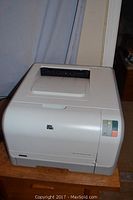 Full view of HP CP1215 laser printer, white body, control buttons on right side