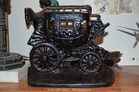 Side view of the black cast iron stagecoach desk lamp showing window details and wheels.