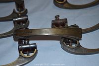 Close-up photo showing the curved brass and Bakelite drawer pull from the lot, highlighting details and condition.