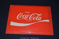 Flat red plastic sign with white 'Enjoy Coca-Cola' text and swoosh design