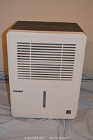 Front view of the white Comfee dehumidifier showing air vents and water level window.