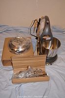 Full view of Sunbeam Mixmaster stand mixer with stainless steel bowl, original box, and additional accessories packaged in plastic.
