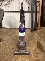 Front view of a Dyson DC41 Animal upright vacuum cleaner with a clear dust bin and ball steering base.