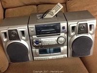 Silver Aiwa stereo system including CD and cassette player, two speakers, and remote control.