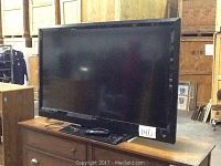 Photo of the Vizio E550VL 54 inch LED TV on a wooden surface showing the full front screen and stand.