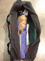 Duffel bag opened showing Murphy Classic women's right handed golf clubs inside, with tan and purple headcover, visible club heads, black shafts, and green interior lining of bag.