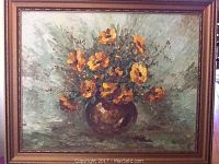 Full view of oil painting on board featuring orange-yellow flowers in a brown vase with textured brushwork and framed in gold-toned gallery frame.