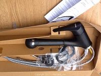 Photo of unopened boxed black matte Blanco pull-out kitchen faucet showing the faucet, braided hoses, mounting hardware, and instruction manual.