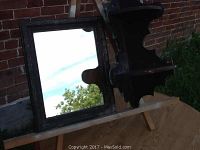 Photo showing the antique wall mirror with carved wooden frame and the corner shelf placed beside it outdoors.