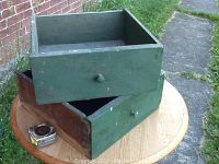 Photo showing both green antique wooden drawers stacked, highlighting size and general condition with some paint wear.