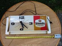 Full view of the rectangular Schmidt's of Philadelphia vintage wall clock with black electric cord and measuring tape showing size.
