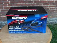 Front of the Simoniz branded box showing the steam cleaner, hose, and car image with product name and key features.