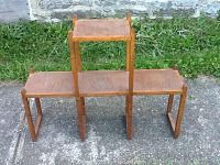 Full view of the wooden plant stand showing three tiers including one elevated middle tier and two lower side tiers.