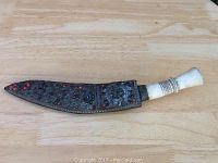 Knife in decorative sheath on a wooden surface showing sheath beadwork