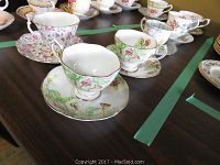Photo showing 6 teacups and saucers arranged on a table, displaying various floral patterns including Royal Albert and Paragon.