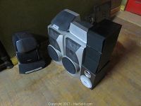 Multiple speakers including Sony, Bang & Olufsen, and Aida models stacked together showing size and style variety.