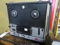 Front view of Sony reel to reel tape recorder with two reel spindles, control knobs, and display meter.