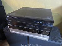 Top view of stacked compact disc players showing Yamaha CDC-575 on top, Habana CD player at middle, and Harman Kardon FL 8385 at bottom.