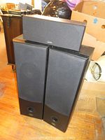 Set of three speakers consisting of one Polk Audio center speaker on top and two Pro Audio floor-standing speakers beneath.