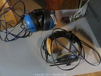 Both pairs of headphones shown on a table, cables visible, displaying condition and physical details.