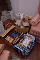 Photo showing boxes and bins filled with vintage and children's books collected together, some stacked horizontally and others vertically.