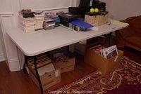 Full side view of the folding table with various items on top and underneath showcasing size and shape.