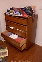 Dresser angled view with drawers partially open showing interior and contents inside drawers and on top.