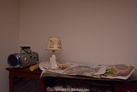 Sylvania compact disk player model SA3082, lamp and posters on a wooden table