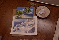 Photo showing the acrylic painting on canvas and two prints lying on a hardwood floor