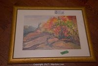 Front view of framed watercolor painting showing fall landscape and gold frame