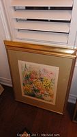 Full view of the framed floral watercolour print showing the beige matte and gold-tone frame.