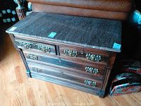 Front view of the dresser showing the marble top and three drawers with metal handles.