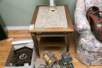 Two matching wooden end tables with stone inlay table tops beside a floral upholstered couch and other household items.